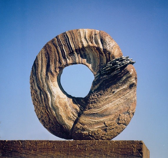 INDICE DE AUDIENCIA (Audience rating) by Juan Ramon Gimeno - In Spain, when we feel forced to accept somebody’s opinion, we use the expression comulgar con piedras de molino (“to swallow communion wafers the size of a millstone”). INDICE DE AUDIENCIA (Audience index) by Juan Ramon Gimeno - Sculpture (1994) Ceramic: 22.7/16” x 20.7/8” x 5.7/8” wood 26” x 9.13/16” x 8.11/16” total height 48.7/16”